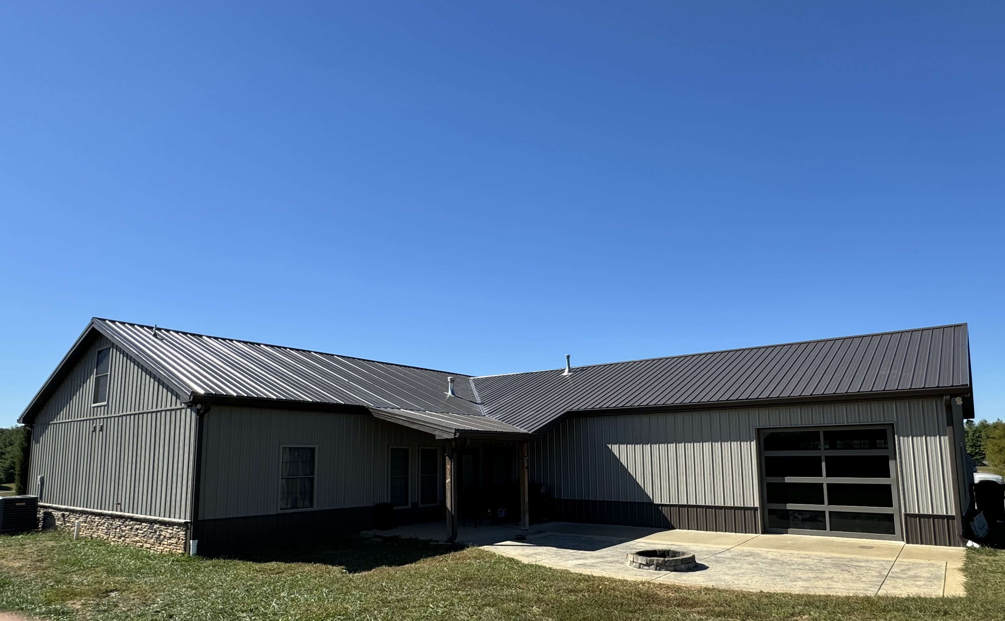A seamless aluminum gutter being installed along the roofline of a house.