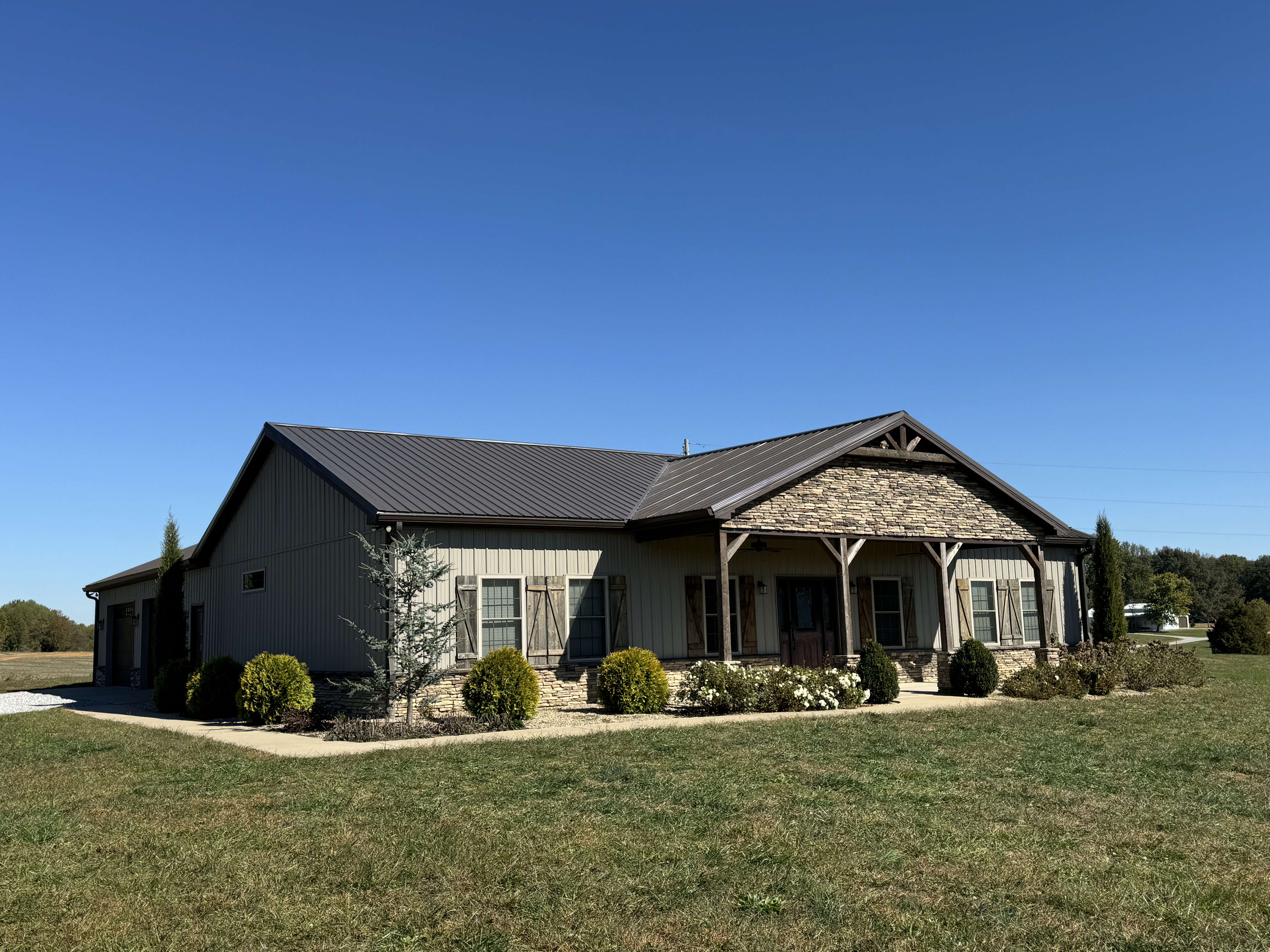 A happy homeowner smiling in front of their new roof.